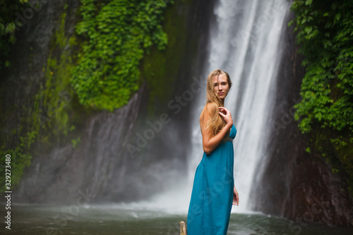 beautiful girl walks near a waterfall