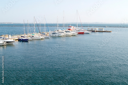 Berth in the port with yachts moored to it. © iama_sing