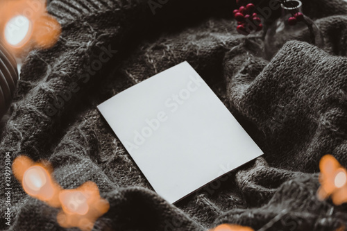 Winter autumn mock up with white book cover. Greetings card new year book mockup with red rowan berries over gray wool plaid. White book cover winter cozy mock-up.Warm festive rowan tree backdrop.