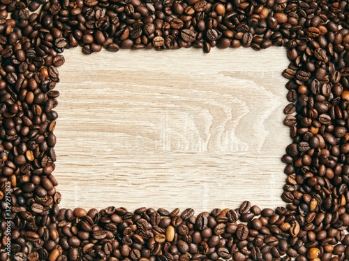 Frame of coffee beans on wood background, copy space