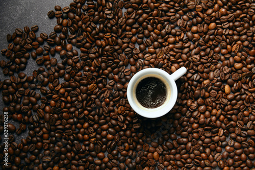 Top view of coffee beans and cup, on a dark ardesia table