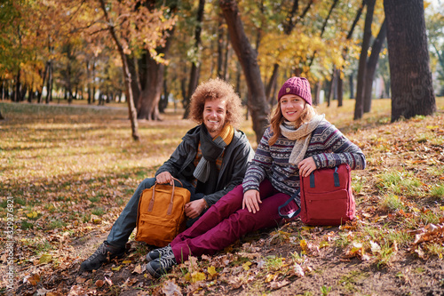 Young couple in casual cloth dating in autumn park.