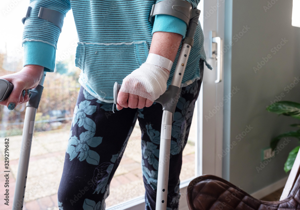 Injured woman trying to walk on Crutches at home