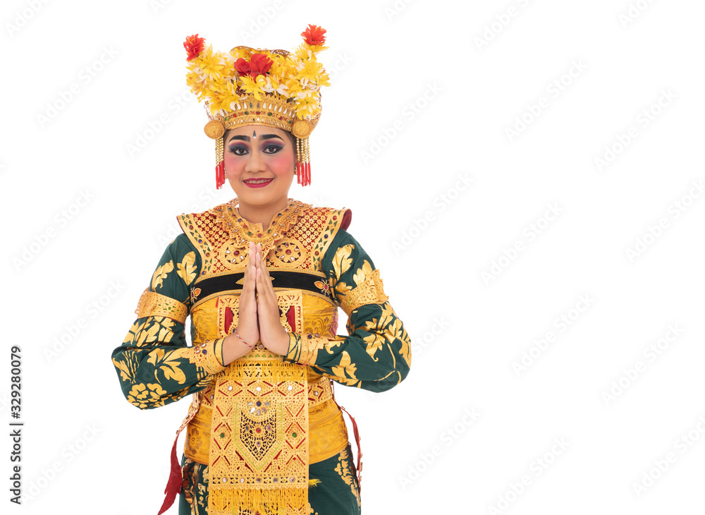 Traditional Balinese dancer woman standing with gestures welcoming beside empty copyspace Traditional Balinese dancer woman standing with gestures welcoming beside empty copyspace