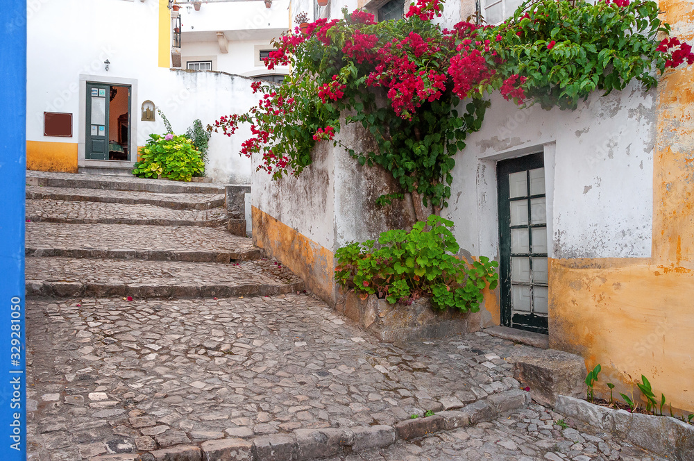 Streets of Obidos. Portugal.  Stonewalled city with medieval fortress. Obidos - famous tourist destination in Portugal for its architecture and history. 