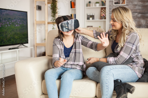 Little girl playing video games using virtual reality goggles