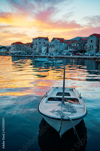 Fototapeta Naklejka Na Ścianę i Meble -  Beautiful sunset landscape. Fishing boat moored on Kastel coast in Dalmatia,Croatia.Old town near Adriatic sea.