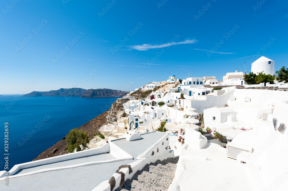 Dazzling midday view of the whitewashed Mediterranean hillside village of Oia in Santorini, Greece