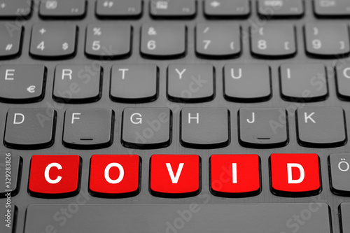 Red "COVID" buttons on the black computer keyboard.