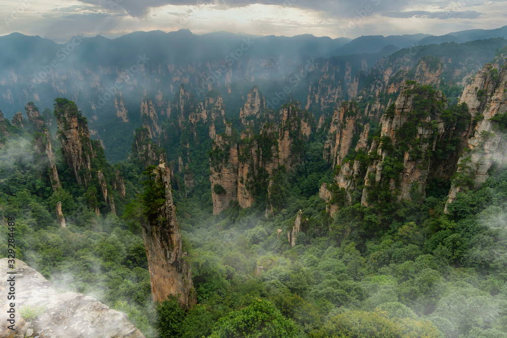 Foggy panorama of mountain range in Yellow Stone Stronghold (Huangshi Zhai) in Yuanjiajie Scenic Area , Zhangjiajie National Park, China - obrazy, fototapety, plakaty 