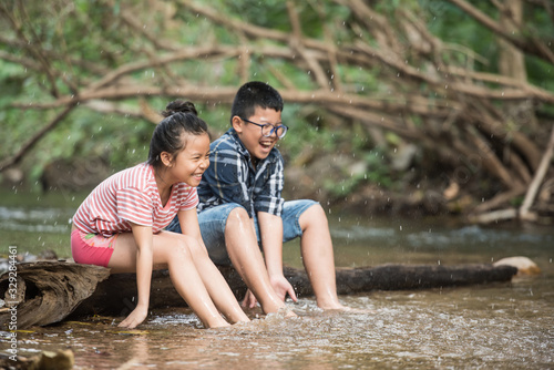 happy group little asian girl and boy child having fun to playing in the river in summer time with smile and laughing healthy, smiling face adorable. Summer camp for kids. vacation lifestyle concept.