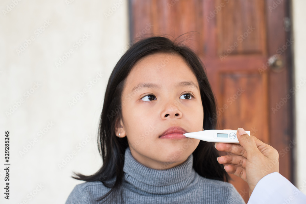 sick little girl with thermometer in mouth. unwell kid with chamber inhaler for cough treatment. flu season. bedroom or hospital room for young patient. healthcare and medicine concept sick little girl with thermometer in mouth. unwell kid with chamber inhaler for cough treatment. flu season. bedroom or hospital room for young patient. healthcare and medicine concept