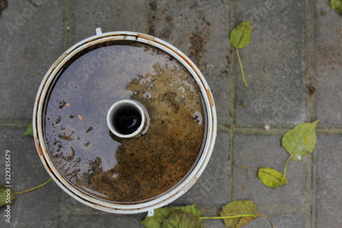 a small bucket filled with cement and sand with a pipe embedded in the middle