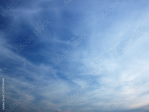 Summer background with white flying clouds on blue sky. Romantic natural heaven backdrop.