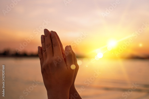 Woman hands place together like praying in front of nature green  background. photo