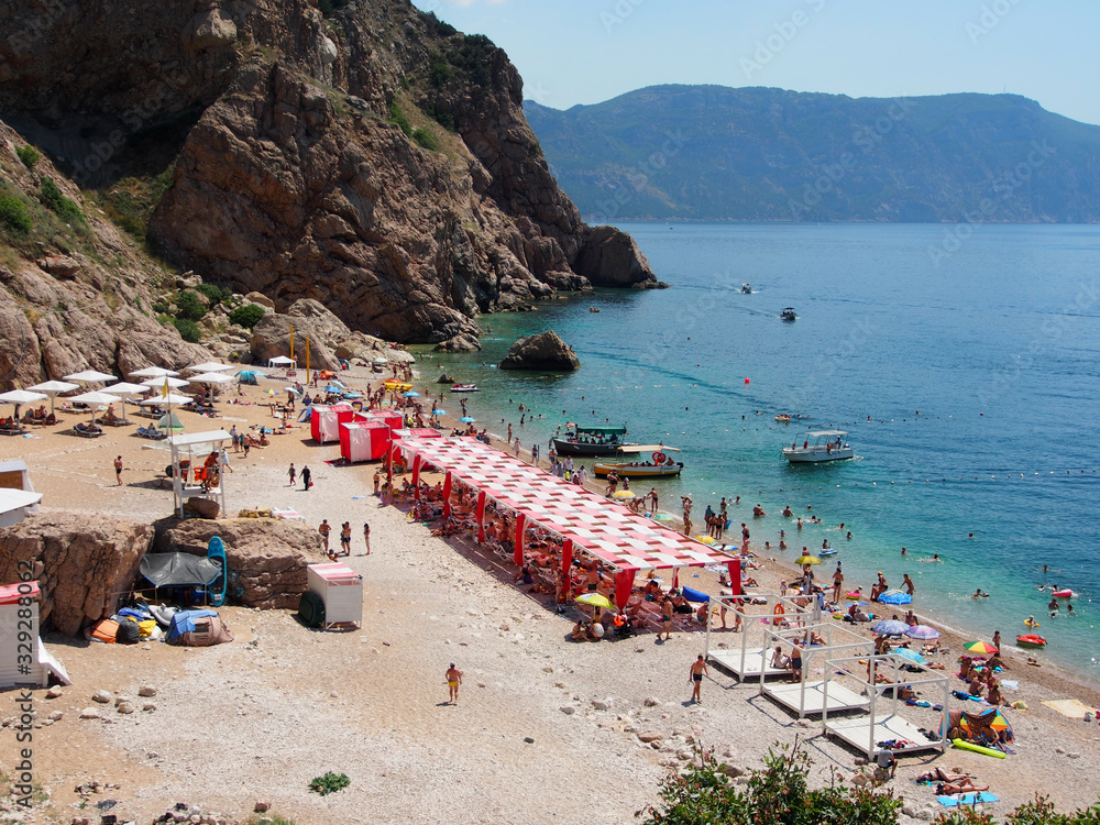 Summer vacation, wide sandy beach against the background of the blue sea and mountains , common plan.