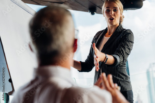 Konstfotografi Businesswoman coach speaker wear suit give blank flipchart presentation, Speaker presenter consulting training persuading employees client group, Business meeting, seminar, presentation concept