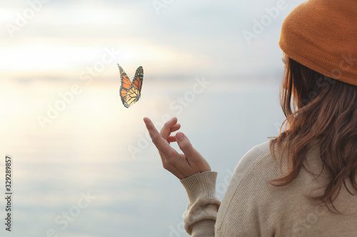 colorful butterfly is laying on a woman's hand photo