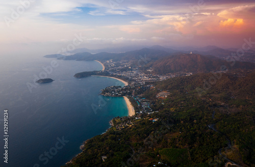 Aerial view of the coastline of Phuket island with tropical sandy beaches and mountains at sunset, Thailand