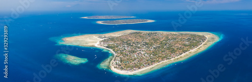 Panoramic aerial drone view of beautiful tropical islands surrounded by coral reef. (Gili Islands, Indonesia)