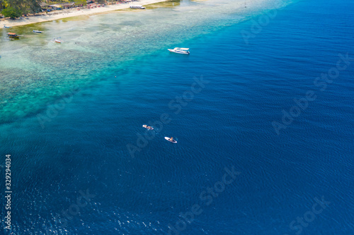 Drone view of Stand Up Paddleboards (SUP) and tourist boats over a beautiful tropical coral reef