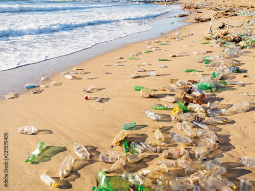 Photography Plastic disposable bottles waste material, washed up on beach by the incoming tide, litter and contaminate an entire beach