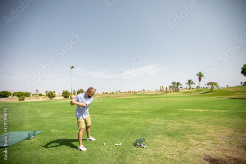 A man on a golf course examines the equipment and prepares for a sporting event at the golf club.