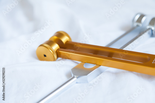 Hand holding a tuning fork and crystal stone  .