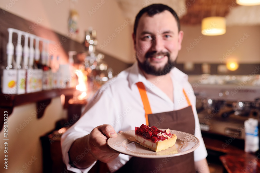 barista or coffee bartender with a delicious piece of cake on the background of a cozy coffee house barista or coffee bartender with a delicious piece of cake on the background of a cozy coffee house