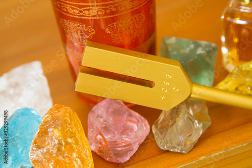Hand holding a tuning fork and crystal stone  .
