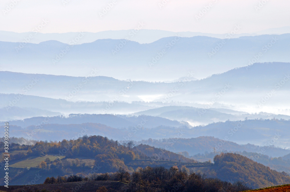  Distant hills in the haze. Beautiful mountain scenery. Mystical rural scenes. Scattered houses of mountain villages. Beautiful nature background.