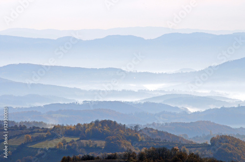 Distant hills in the haze. Beautiful mountain scenery. Mystical rural scenes.  Scattered houses of mountain villages. Beautiful nature background. © Cveja
