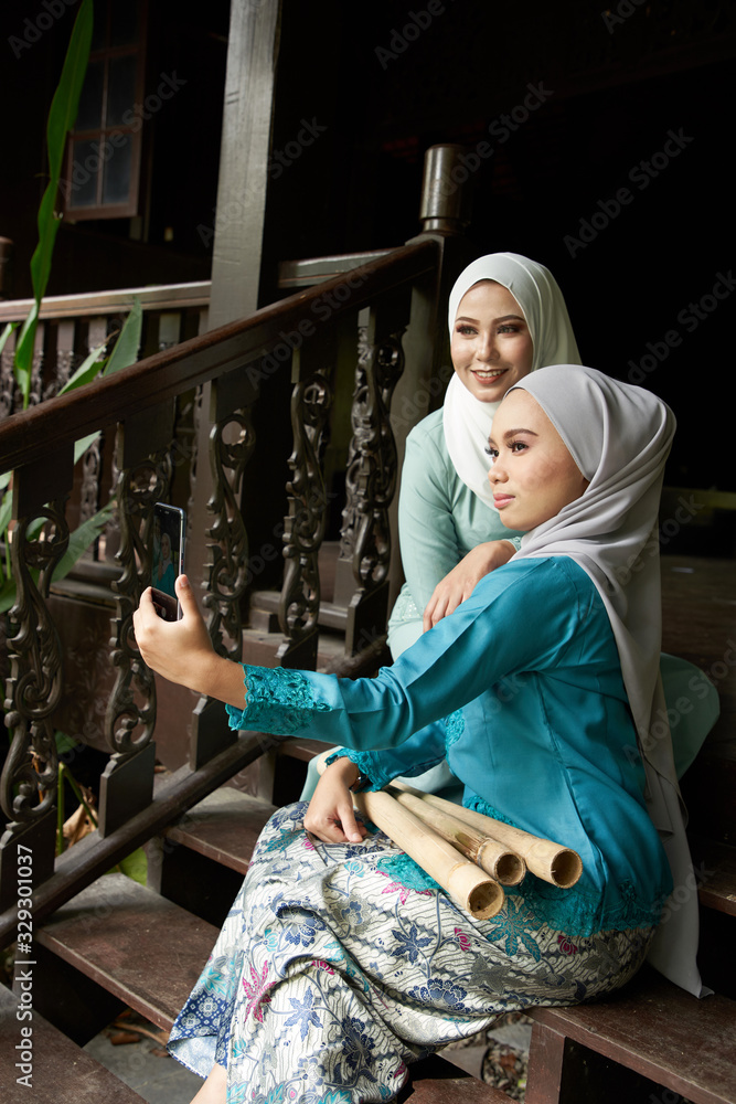 hijab take selfie together with smartphone