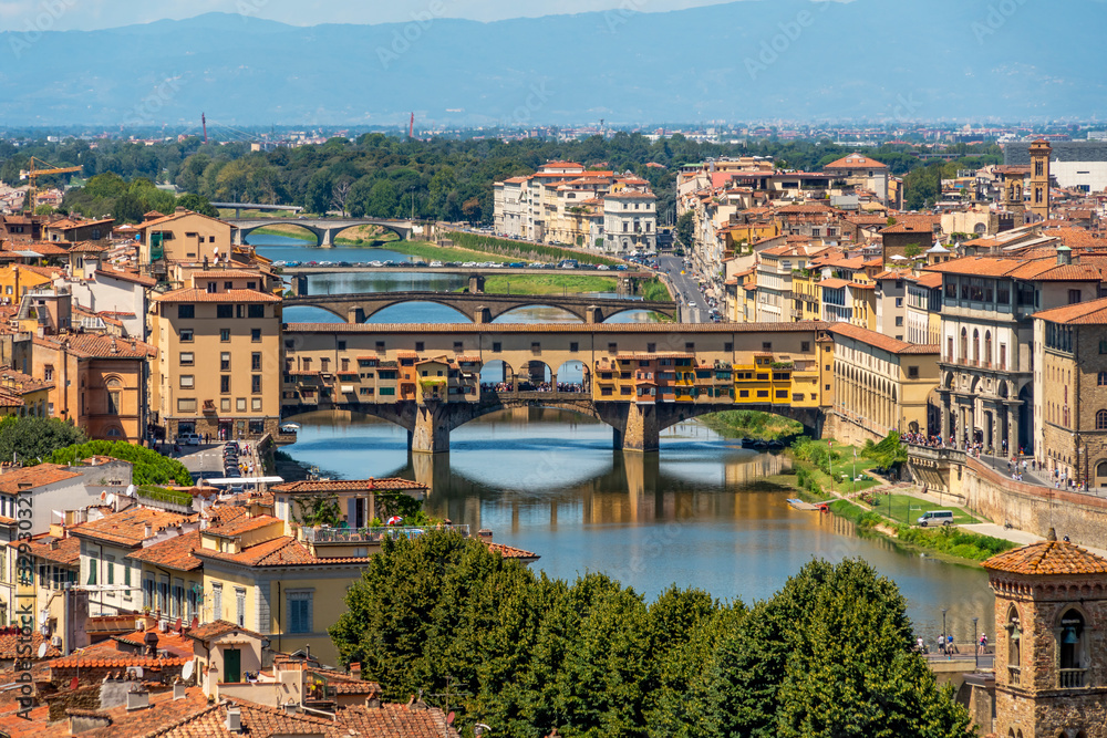 Beautiful wide angle view of the Florence bridges over Arno river in hot summer day. Travel destination Tuscany, Italy