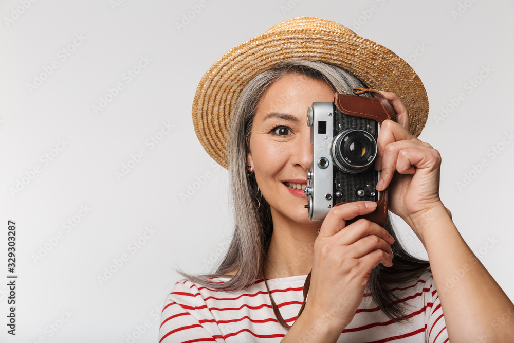 Image of adult woman wearing straw hat photographing on retro camera Image of adult woman wearing straw hat photographing on retro camera
