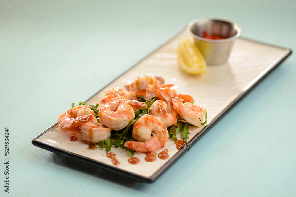 Shrimp or prawn salad, with arugula and a healthy lemon and parsley dressing served on a white plate