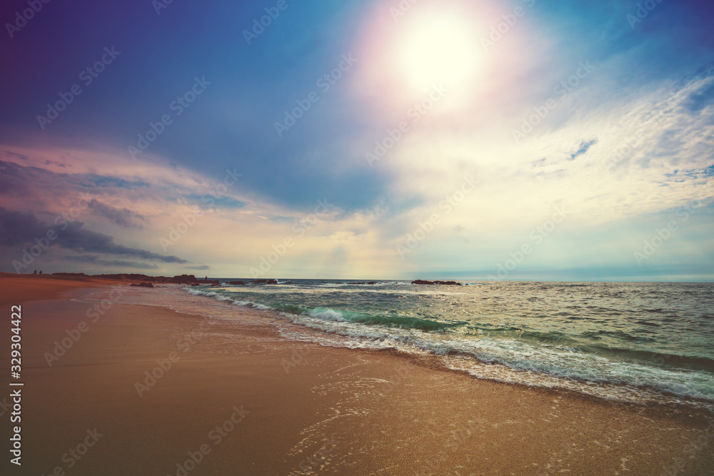 Seascape in the evening. Sunset on the beach. Sandy seashore with beautuful sky