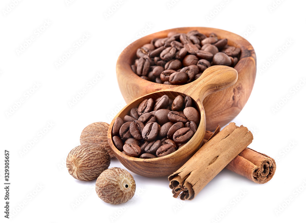 Fototapeta premium Coffee beans in a wooden spoon with cinnamon and nutmeg on white background.