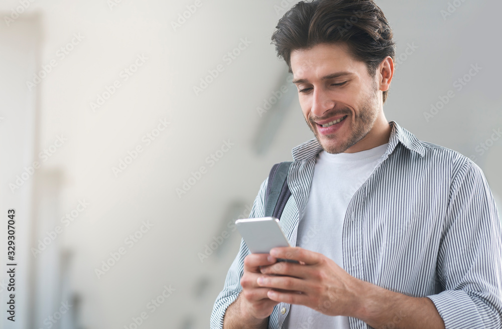 Young Man Using Smartphone While Waiting For His Flight In Airport Young Man Using Smartphone While Waiting For His Flight In Airport