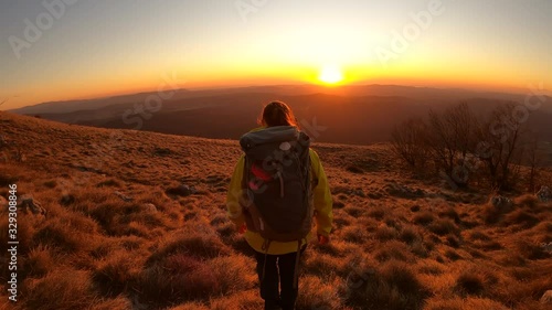 Woman hiking into the beautiful sunset