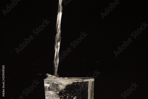 Drinking water falling in a glass