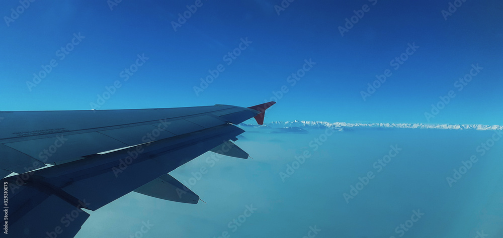 wing of airplane flying above clouds wing of airplane flying above clouds