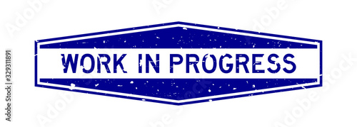 Grunge blue work in progress word hexagon rubber seal stamp on white background
