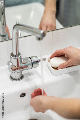 A woman washes her hands carefully with soap