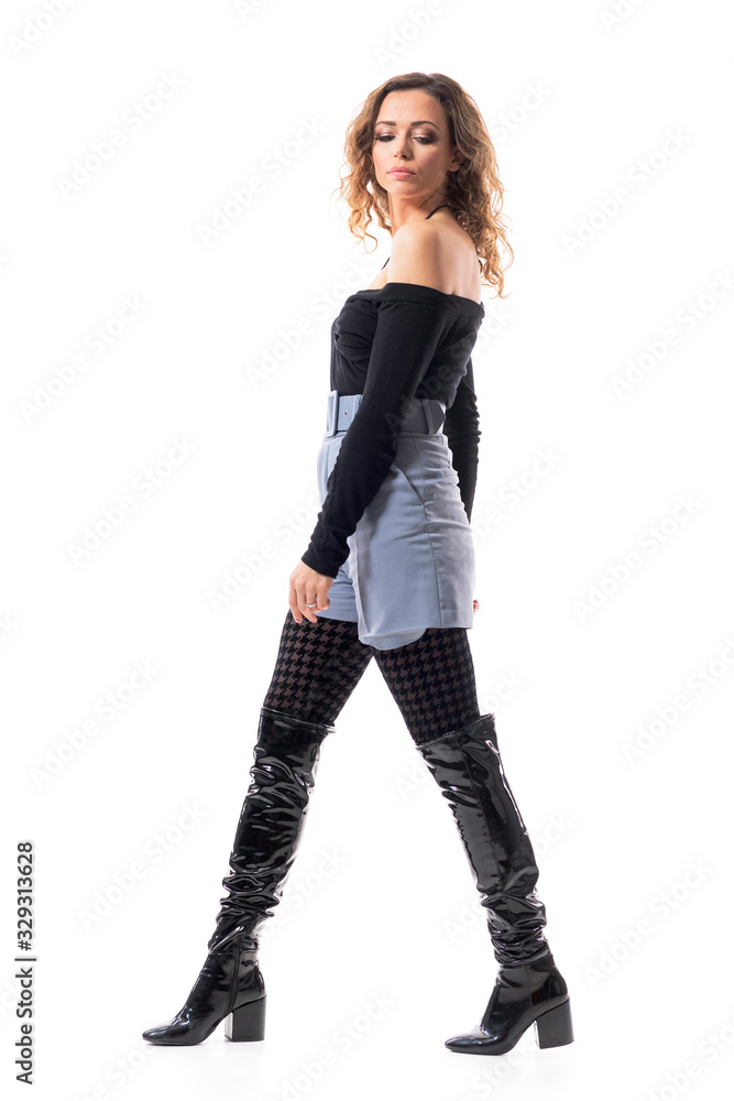 Fashionable modern young beauty woman in stylish clothes walking and looking down. Side view. Full body length isolated on white background. Fashionable modern young beauty woman in stylish clothes walking and looking down. Side view. Full body length isolated on white background.