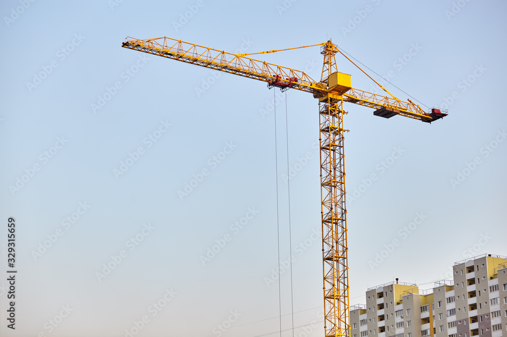 Building crane and building under construction against sky