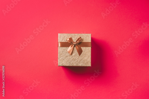 Valentine's Day. Golden gift box on red background. Top view. Copy space. Festive backdrop for holidays: Birthday, Valentines day, Christmas, New Year. Flat lay style. Banner