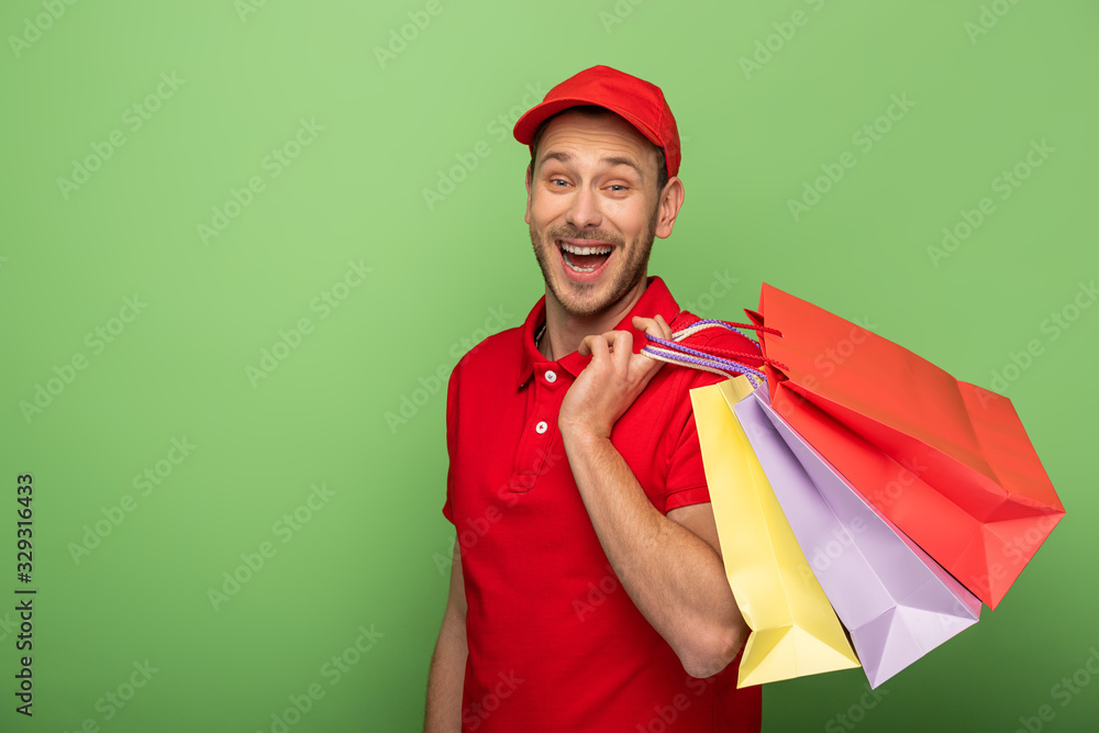 excited delivery man in red uniform holding shopping bags on green excited delivery man in red uniform holding shopping bags on green