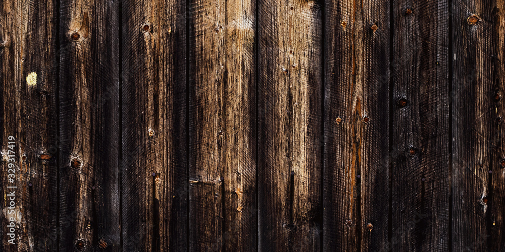 Rustic old wood background, dark wooden texture, wide panoramic banner. Natural weathered fence with nails. Brown planks timber floor. Rustic old wood background, dark wooden texture, wide panoramic banner. Natural weathered fence with nails. Brown planks timber floor.