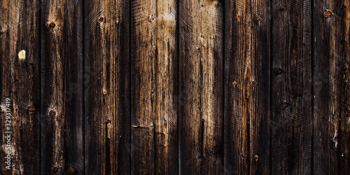 Rustic old wood background, dark wooden texture, wide panoramic banner. Natural weathered fence with nails. Brown planks timber floor.